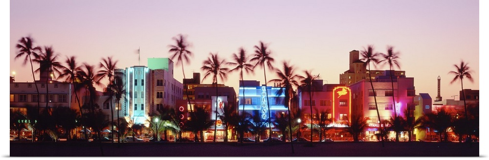 A panoramic photograph of a sunset featuring Miami's Ocean Drive and the neon lights of the Art Deco District.