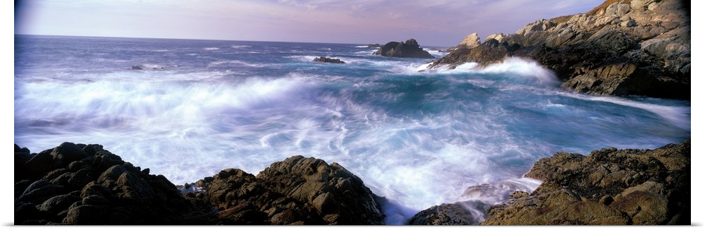 Panoramic photograph on a large canvas of ocean waves crashing into the rocks near San Simeon Point, California.