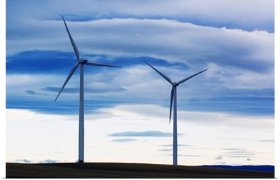 Pair of wind farm turbines, cloudy sky, Montana