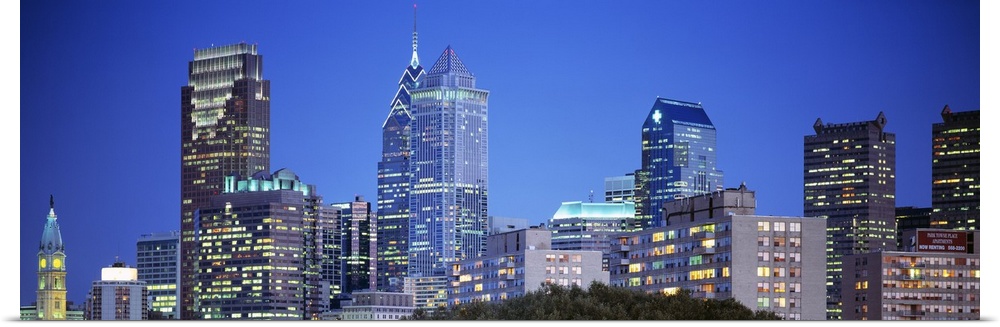 Panoramic photograph of the Philadelphia skyline during night with the buildings windows illuminated.