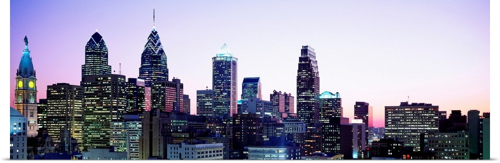 A panoramic photograph of the downtown city skylineos skyscrapers at dusk.