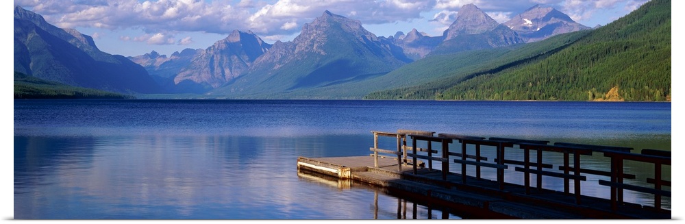Dock on the water with mountains in the background at Lake McDonald Glacier National Park in Montana.