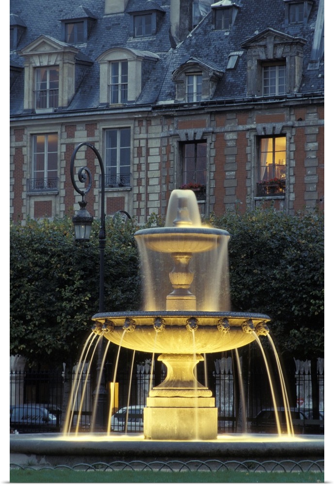 Tall image of a water fountain lit up at night in Paris.