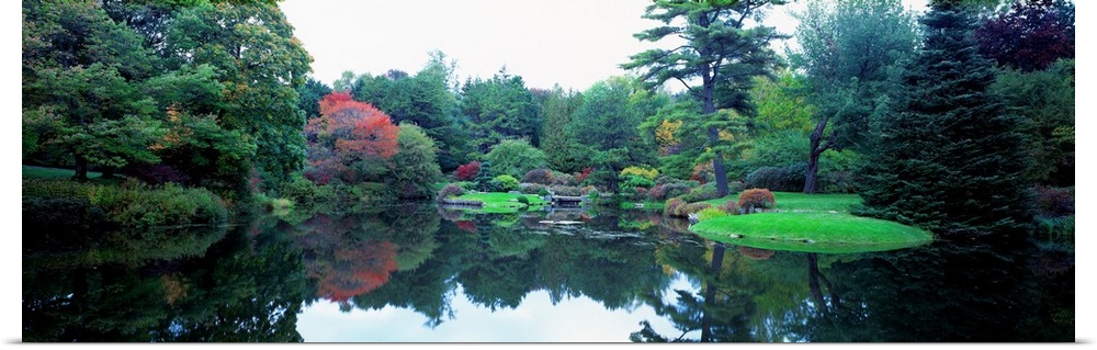 Panoramic photograph of the vibrant Asticou Azalea Garden reflecting in the water of a large pond, in Northwest Harbor, Ma...