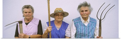 Portrait of three senior women holding gardening tools, Baden-Wurttemberg, Germany