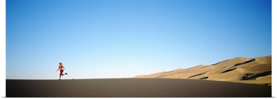 Rear view of a woman running in the desert, Great Sand Dunes National Monument, Colorado