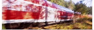 Red commuter train passing through a forest, Baden-Wurttemberg, Germany