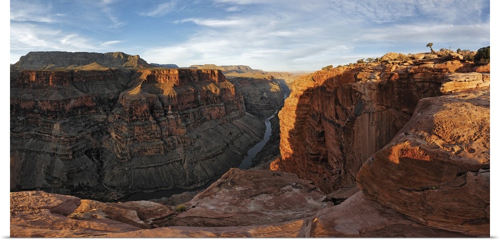 Large canvas photo of Grand Canyon cliffs draped in sunlight and shadows with a river running through them at the base.