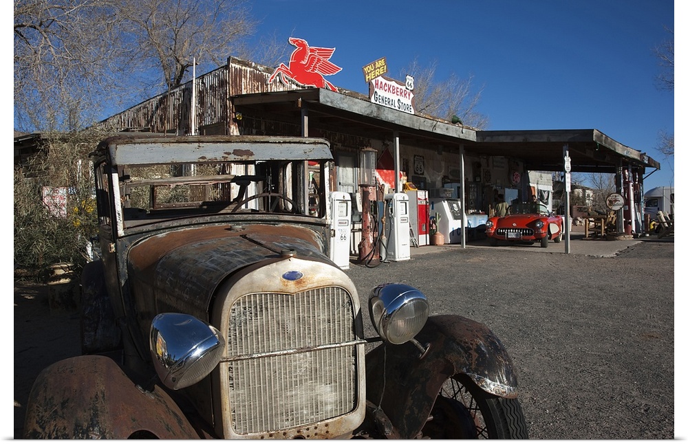 Photograph of vintage car at old garage and gas station.