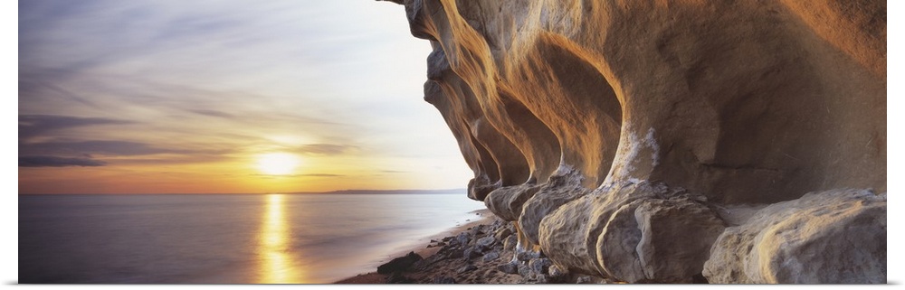 Eroded rocks by the sea in this panoramic photograph; this is landscape wall art for the office or home.