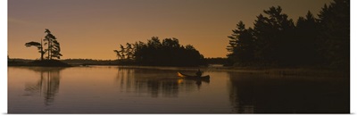 Silhouette of a person in a canoe on a lake, Kejimkujik Lake, Kejimkujik National Park, Nova Scotia, Canada