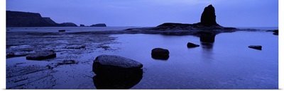 Silhouette of rocks on the beach, Black Nab, Whitby, England