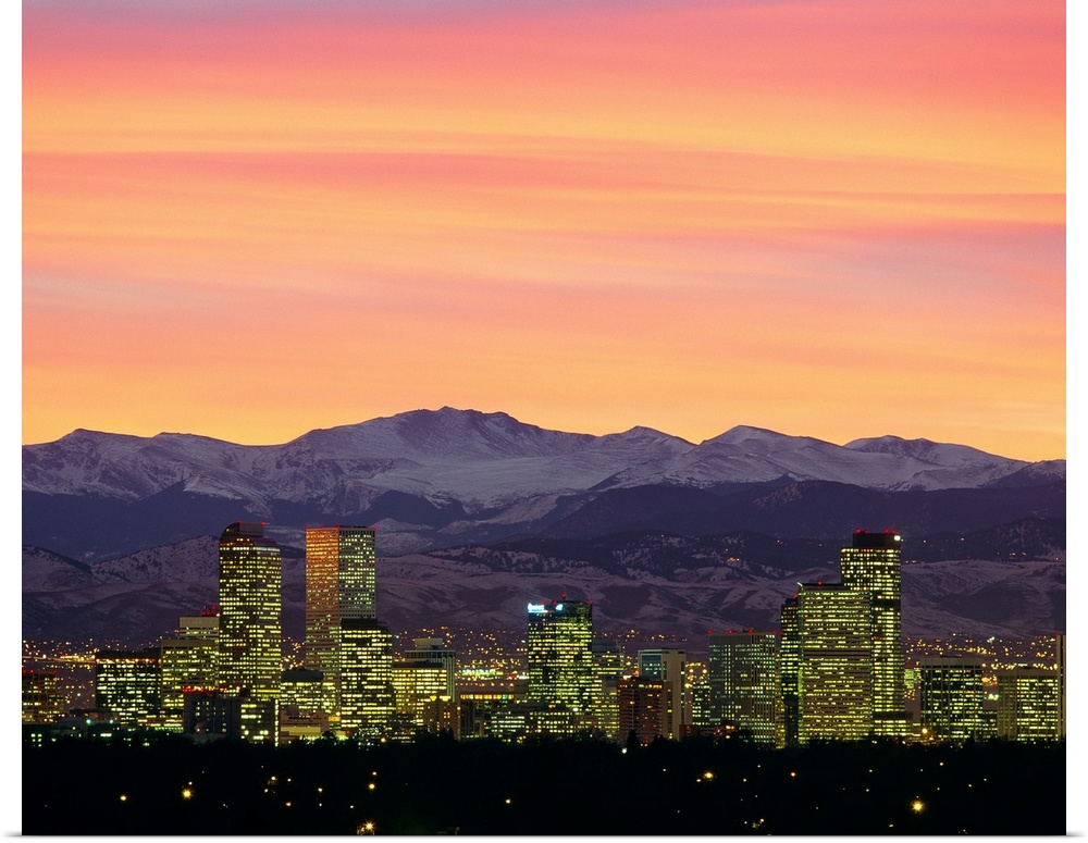 Large photograph taken of the Denver, Colorado skyline at dusk.  The snow covered mountains in the background provide a gr...
