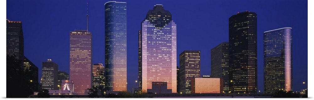 Large panoramic view of the Houston skyline with the buildings illuminated during the night.