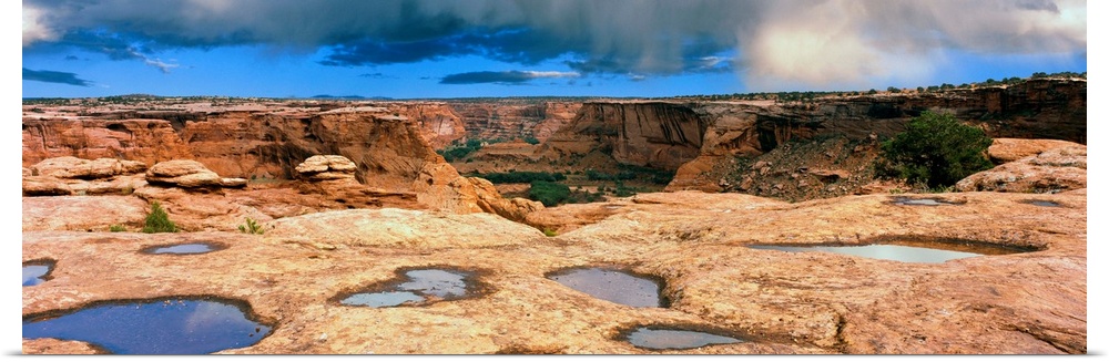 Slickrock waterpocket pools reflect sunrise colors, Canyon De Chelly National Monument, Arizona, USA.