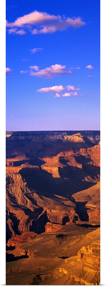 This vertical panoramic print is a photograph taken of part of the Grand Canyon on a sunny day.