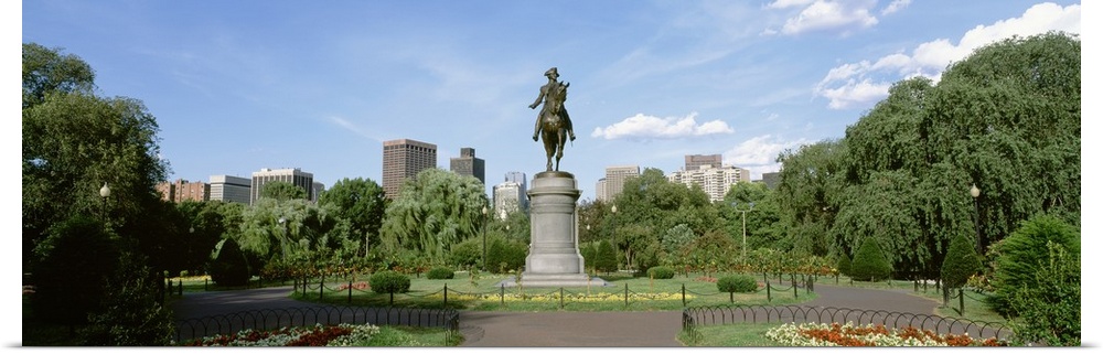 Statue of a man riding a horse in the middle of well kept city park in Boston, Massachusetts.