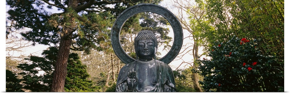This Buddha statue is pictured as a panorama with trees scattered about in the background.