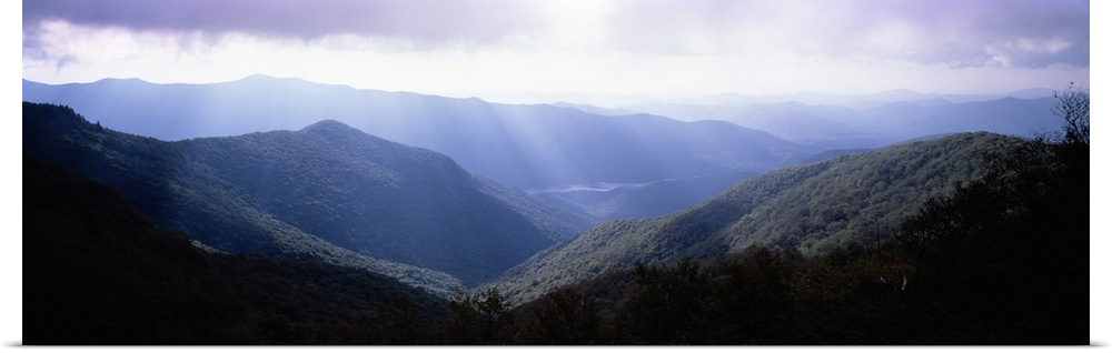Wide angle photograph of the sun shining down on the Blue Ridge Mountains in North Carolina.