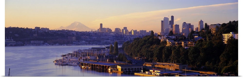 Dawn on the shoreline of a harbor in a Northwestern city, with the faint image Mount Rainier in the distance.