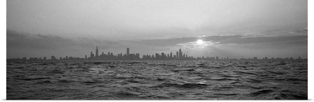 Wide angle photograph of sunset over choppy waters of Lake Michigan, the Chicago skyline in the distant horizon.