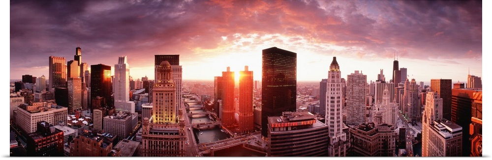 This wall hanging is a panoramic photograph of the city skyline and the sun disappearing between two skyscrapers.