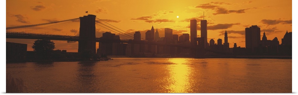This wall art for the home or office is a panoramic photograph of the Manhattan skyline silhouetted in the evening light.