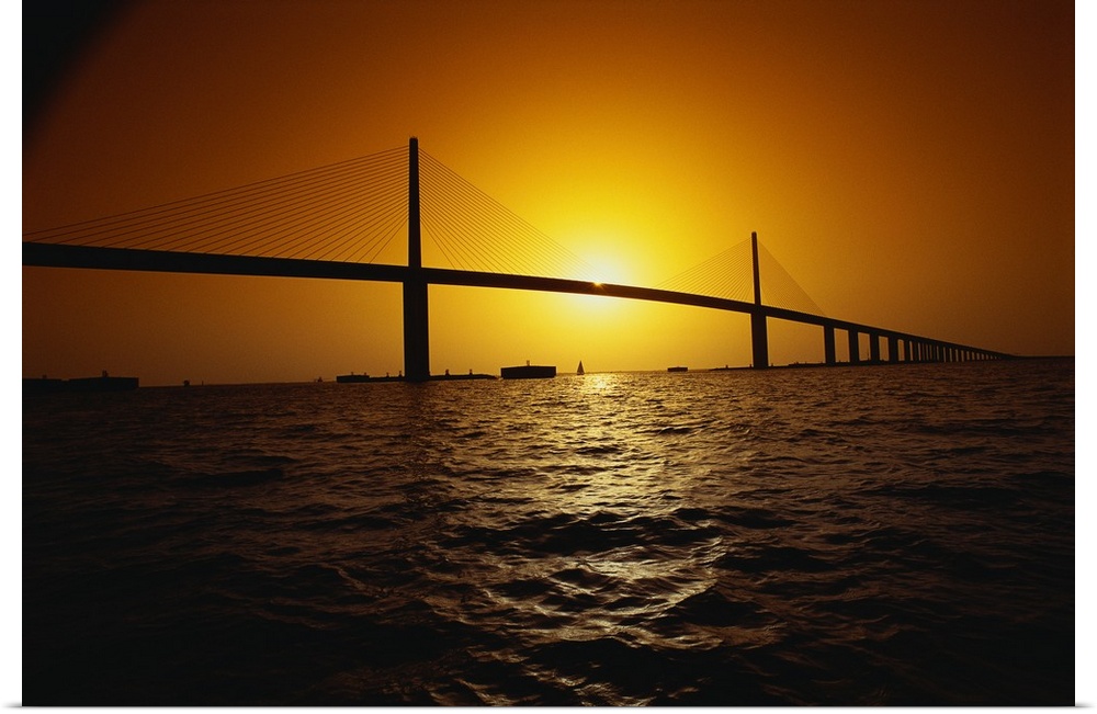 Setting sun framed by the two towers of the Sunshine Skyway bridge, a concrete cable-stayed structure in Florida.