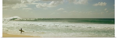 Surfer standing on the beach, North Shore, Oahu, Hawaii,