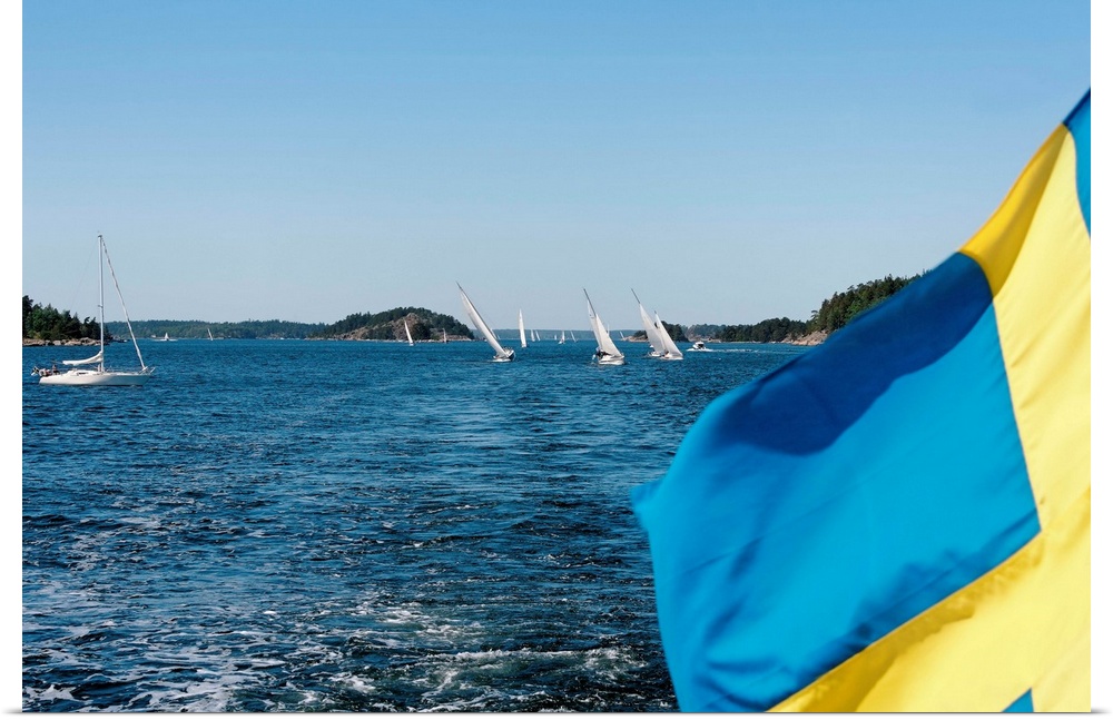 Close-up of a Swedish flag with sailboats in the background, Stockholm Archipelago, Stockholm, Sweden