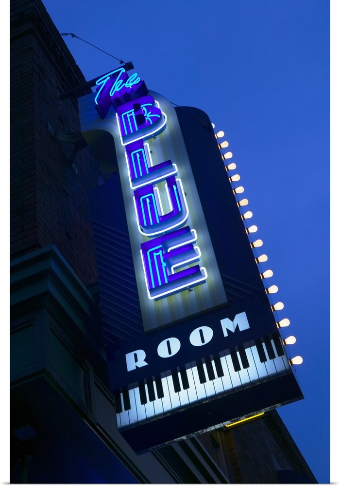 This is a vertical photograph of a neon sign outside popular musical venue.