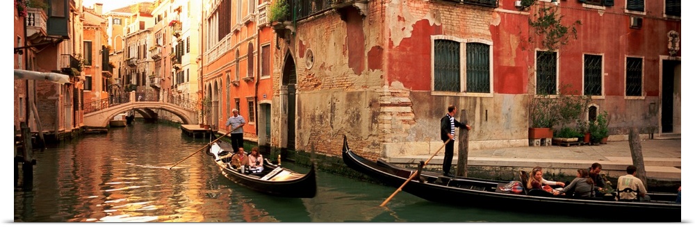Gondolas paddling through canals lined with historic Venetian buildings.