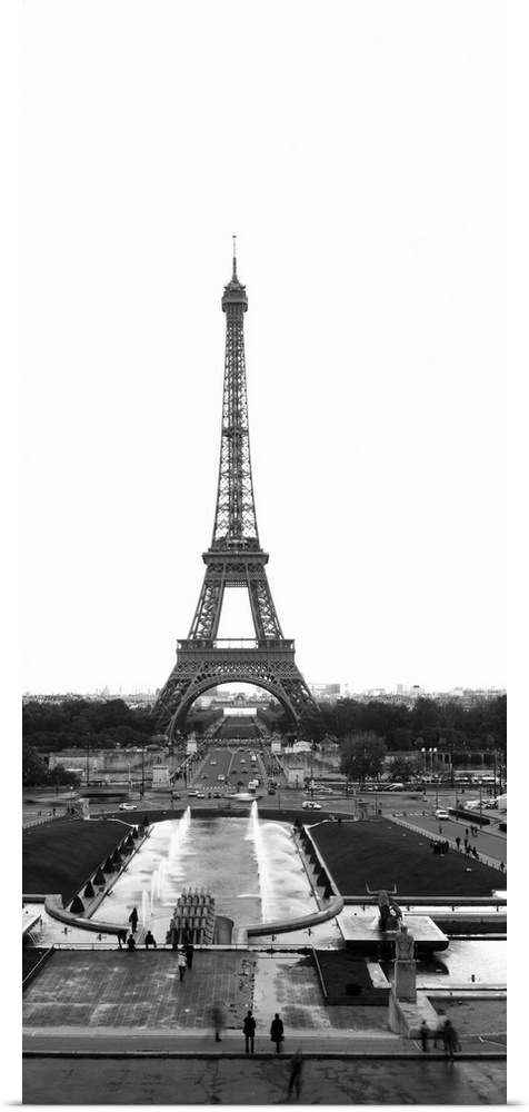 Black and white photograph of the Eiffel Tower as seen from the edge of the plaza. The tower contrasts sharply with the ov...
