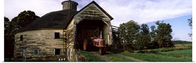 Tractor parked inside of a round barn, Vermont,