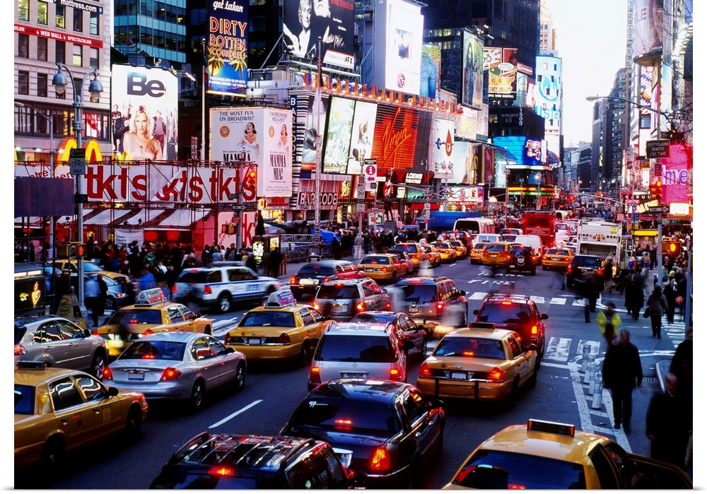 A landscape photograph of the chaotic city traffic crowded with taxi cabs, personal vehicles, and pedestrians.