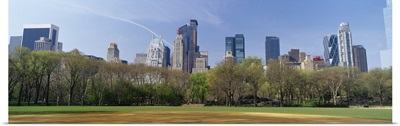 Trees in a park with buildings in the background, Central Park South, Central Park, Manhattan, New York City, New York State