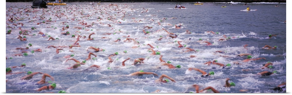 Sports action photograph of hundreds of swimmers racing in the Ironman in Kailua Kona, Hawaii.