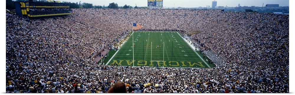 Wide angle, aerial photograph of Michigan Stadium full of fans, during a University of Michigan football game in Ann Arbor.