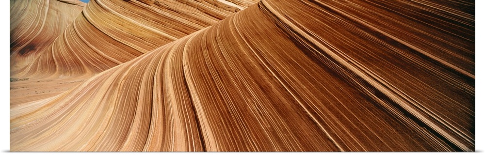 Desert cliff walls streaked with red rock lines flowing through a canyon.