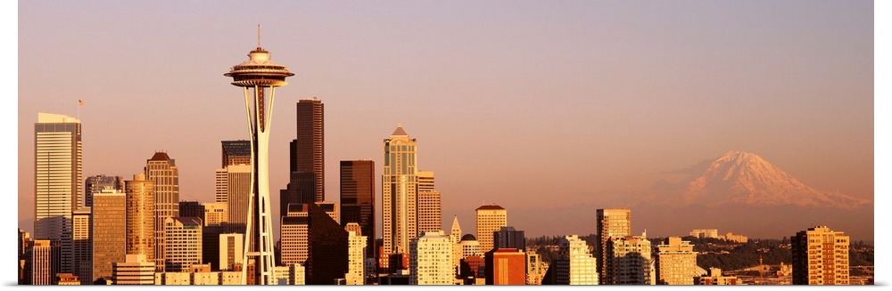 This panoramic photograph is the city skyline at sunset with Mount Rainer in the background.