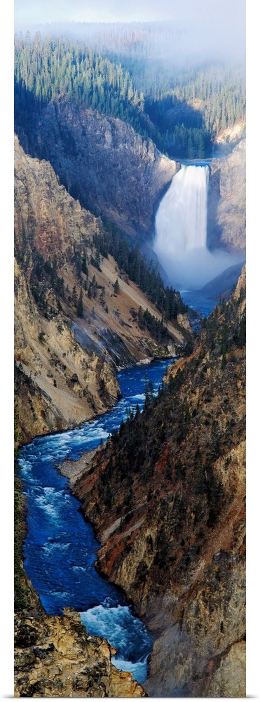 Giant panoramic artwork of a waterfall dumping water into a small river at the bottom of a canyon in Yellowstone National ...