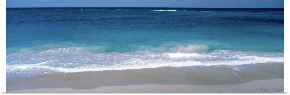 Panoramic picture of waves coming up on the white sandy beach in the Caribbean.