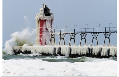 Wave crashing on snow-covered South Pier lighthouse, South Haven, Michigan