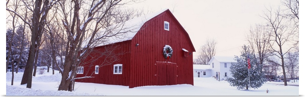 Panoramic image print of a big barn in the middle of the snow with a wreath on it.
