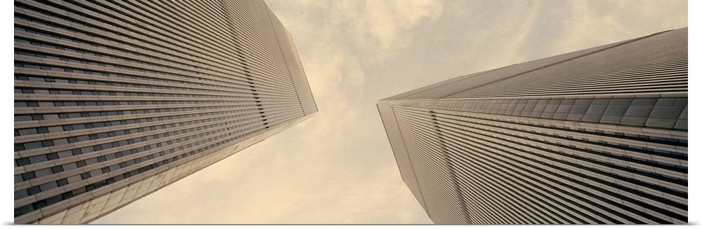Panoramic photograph taken from the ground looking up at the nicknamed "Twin Towers" as they extend toward the daytime sky...