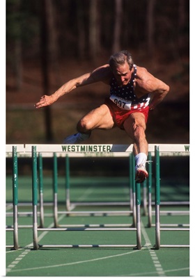 Elderly male track and field athlete hurdling