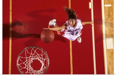 Female basketball player going up for a shot