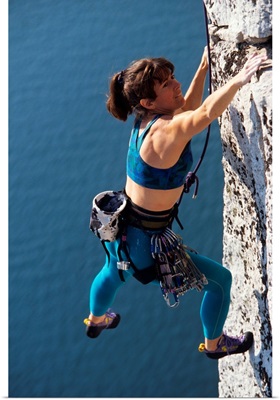 Female rock climber reaching for a grip
