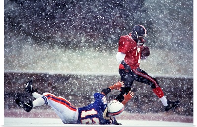 Football players in action during snowy game