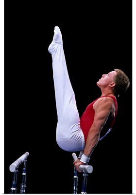 Male gymnast performing on the parallel bars